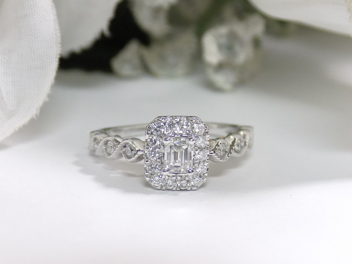 .75ct TW Halo Style Natural Emerald Cut Diamond Engagement Ring in Solid 14K White Gold with Rose Gold Accents on Side View with a Single Blue Sapphire